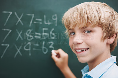 Buy stock photo A young boy doing his sums on a blackboard with a piece of chalk - copyspace