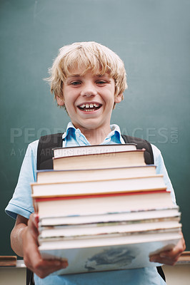 Buy stock photo An eager young student carrying a tall stack of books and smiling at you