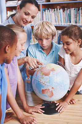 Buy stock photo A group of schoolchildren learning about the world with their geography teacher
