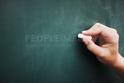Buy stock photo Cropped image of a young boy's hand writing on a blackboard with a piece of chalk