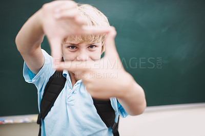 Buy stock photo Chalkboard, fingers frame and portrait of boy in classroom at school for development or education. Hand gesture, learning and study with happy student in class for future, growth or scholarship