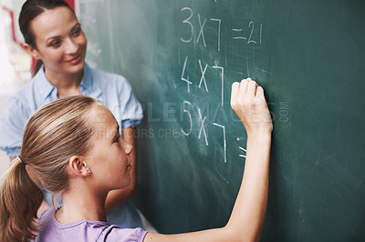 Buy stock photo Math, teacher and student writing on chalkboard in classroom for solving number problem and answer question. Lesson, girl and solution for multiplication at school with scholarship, quiz and learning