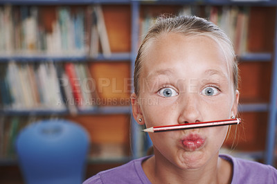 Buy stock photo A cute young girl balancing her pencil on her lips and pulling a face