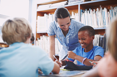 Buy stock photo Support, teacher and student with questions in a classroom or library for learning development. Education, kids and children asking help from woman with smile and knowledge for assignment at school