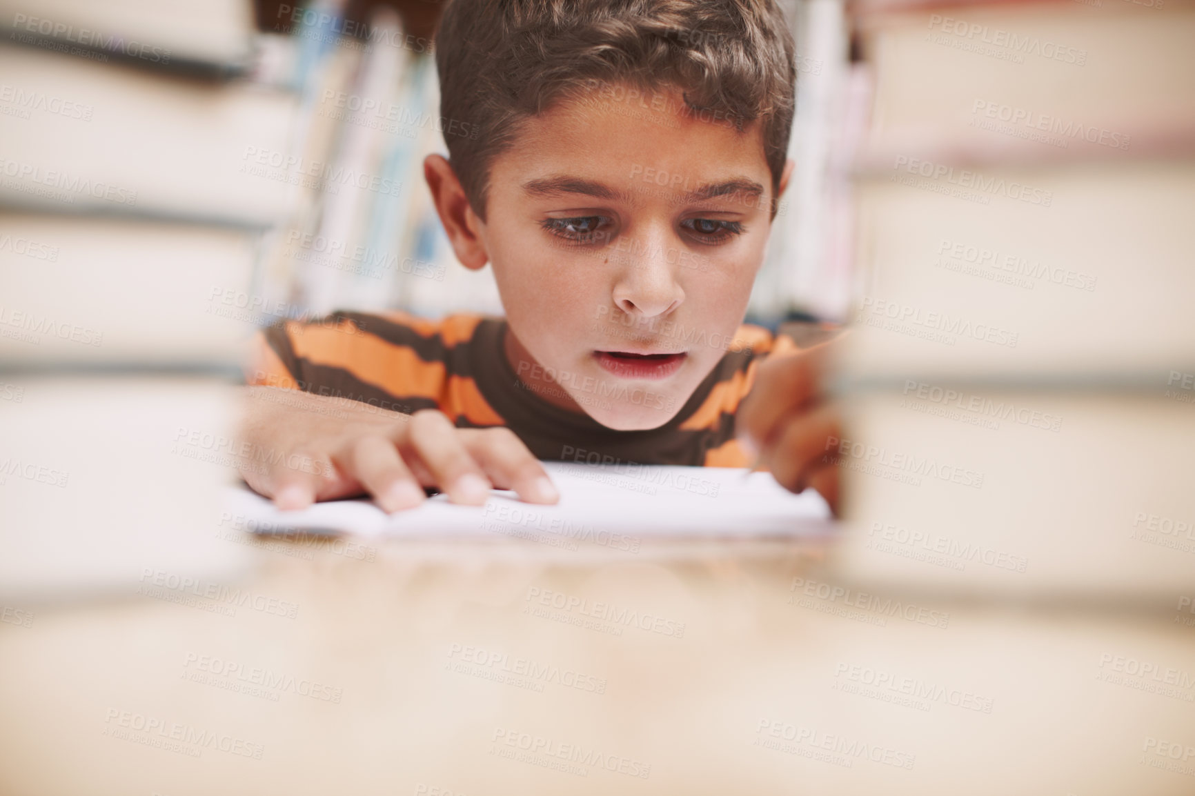 Buy stock photo Child, writing and study in library for education, knowledge and solution for development at elementary school. Young boy, learning and books on table for lesson, growth and progress in assessment