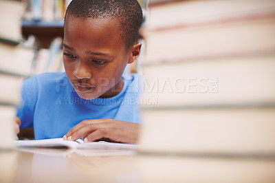 Buy stock photo Black child, writing and study in library for education, knowledge or academic opportunity at elementary school. Young boy, learning or books on table for lesson, growth and progress in assessment