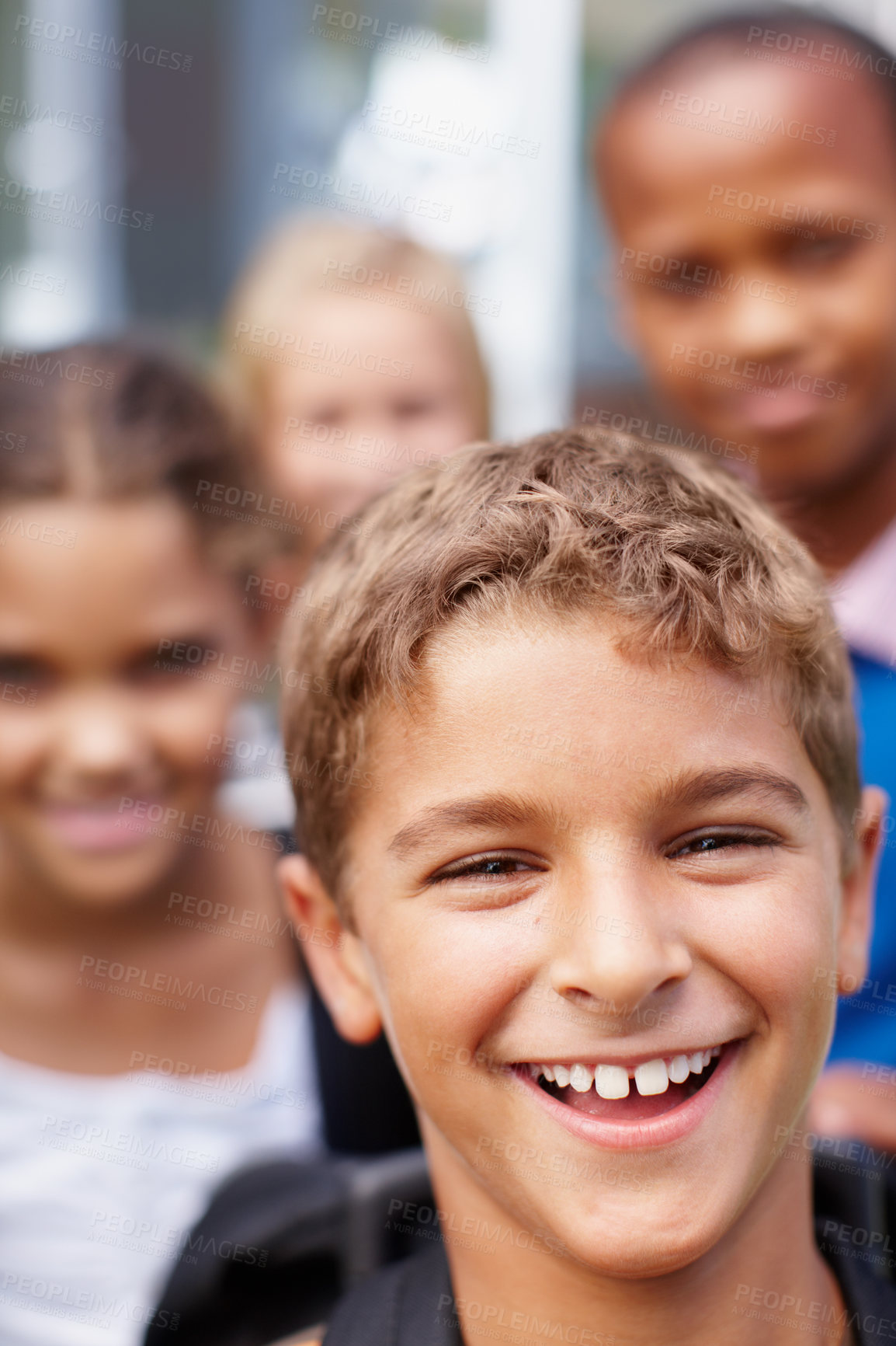 Buy stock photo Closeup of a laughing little boy with friends in the background - copyspace