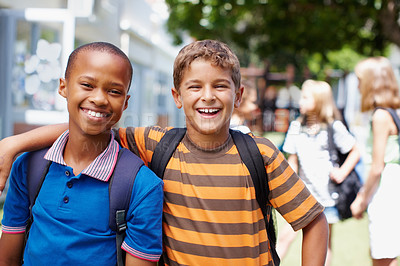 Buy stock photo Two boys standing outside their school in casual clothes smiling happily at you - copyspace
