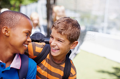 Buy stock photo Multi-racial pair of school buddies smiling at each other outside their school - copyspace