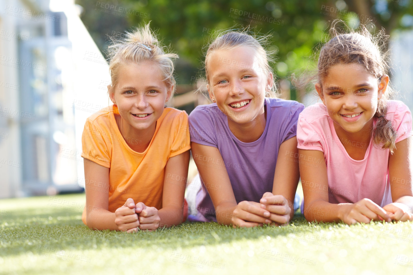 Buy stock photo Outdoor, friends and children in portrait for lying, connection and bonding together with happiness. Grass, relax and girls with laughing for childhood games, smile and reunion for school holiday