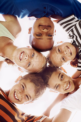 Buy stock photo Low view of a group of schoolchildren looking down at you and huddling together