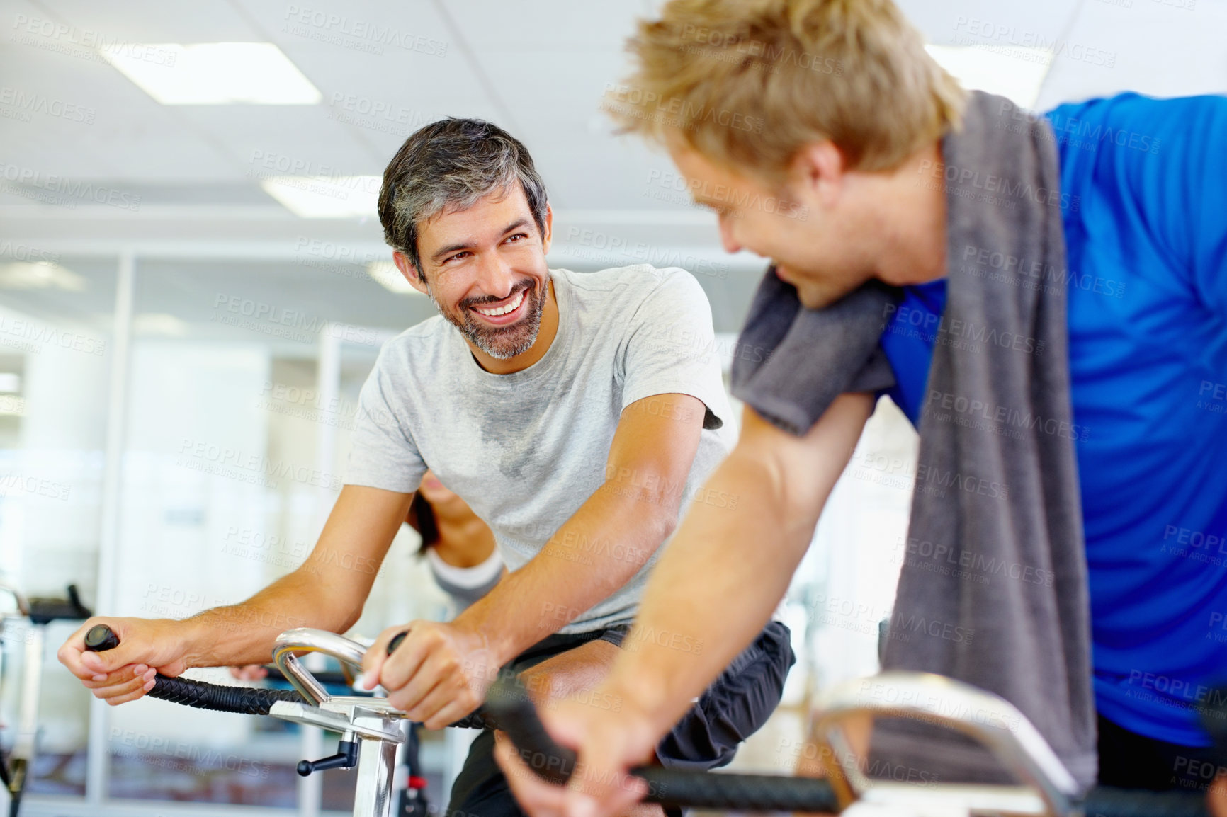 Buy stock photo Men talking while on stationary bike it the gym
