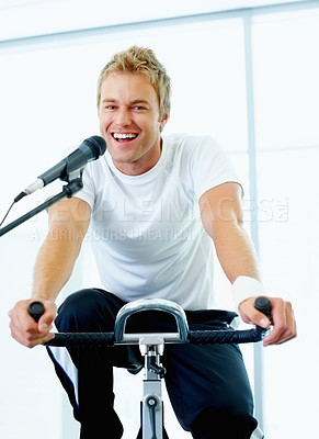 Buy stock photo Handsome man singing a song while spinning bike at the gym