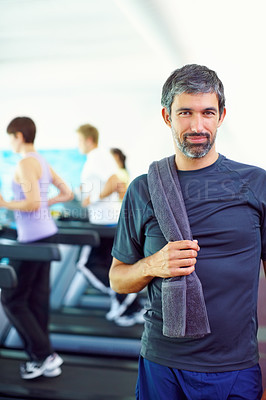 Buy stock photo Portrait of middle aged man holding towel with people exercising in background