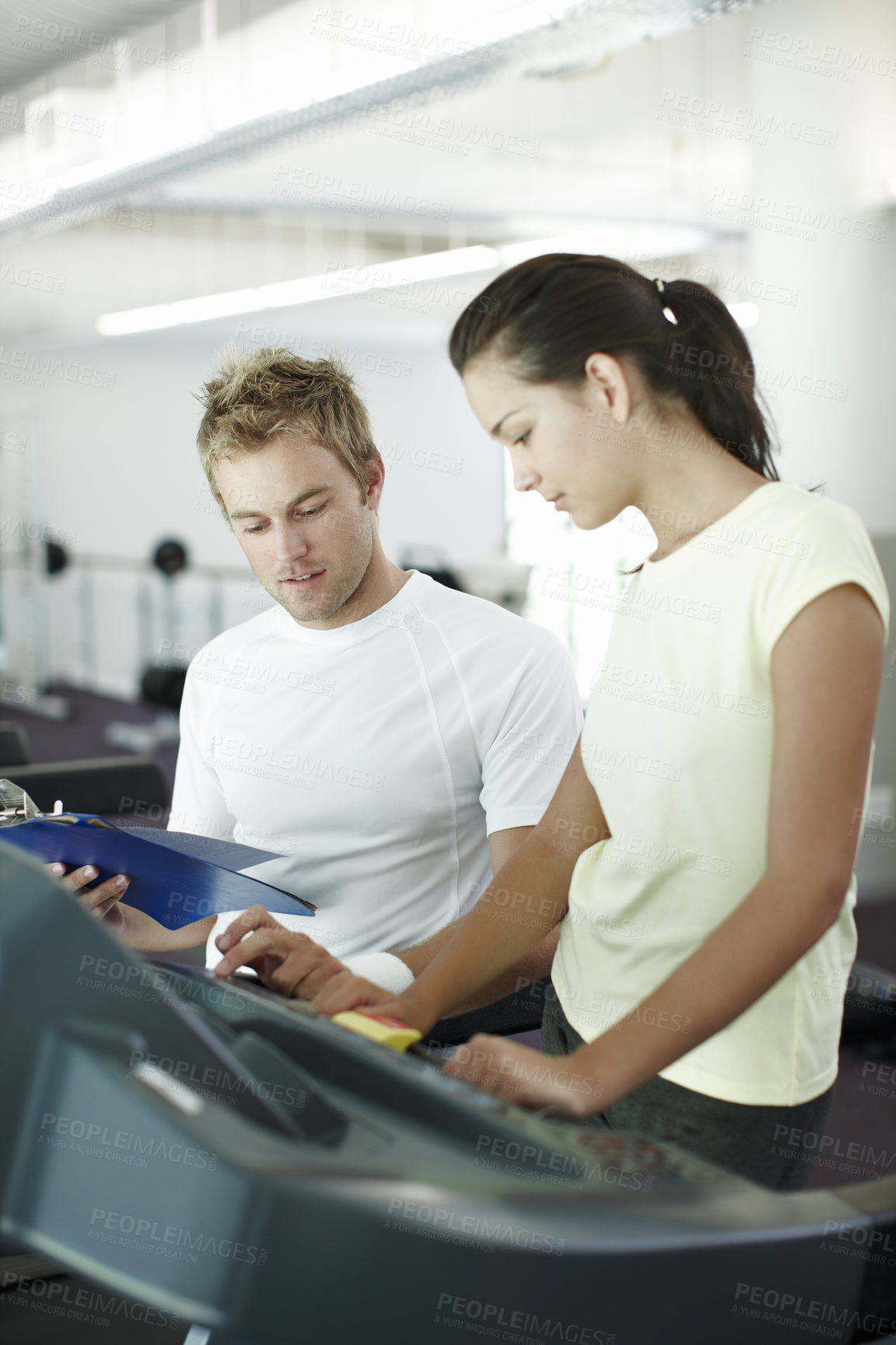 Buy stock photo Cropped shot of an attractive young woman working out with her personal trainer