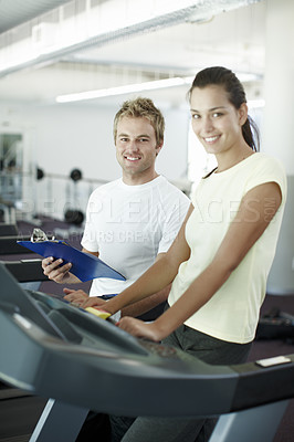 Buy stock photo Cropped portrait of an attractive young woman working out with her personal trainer