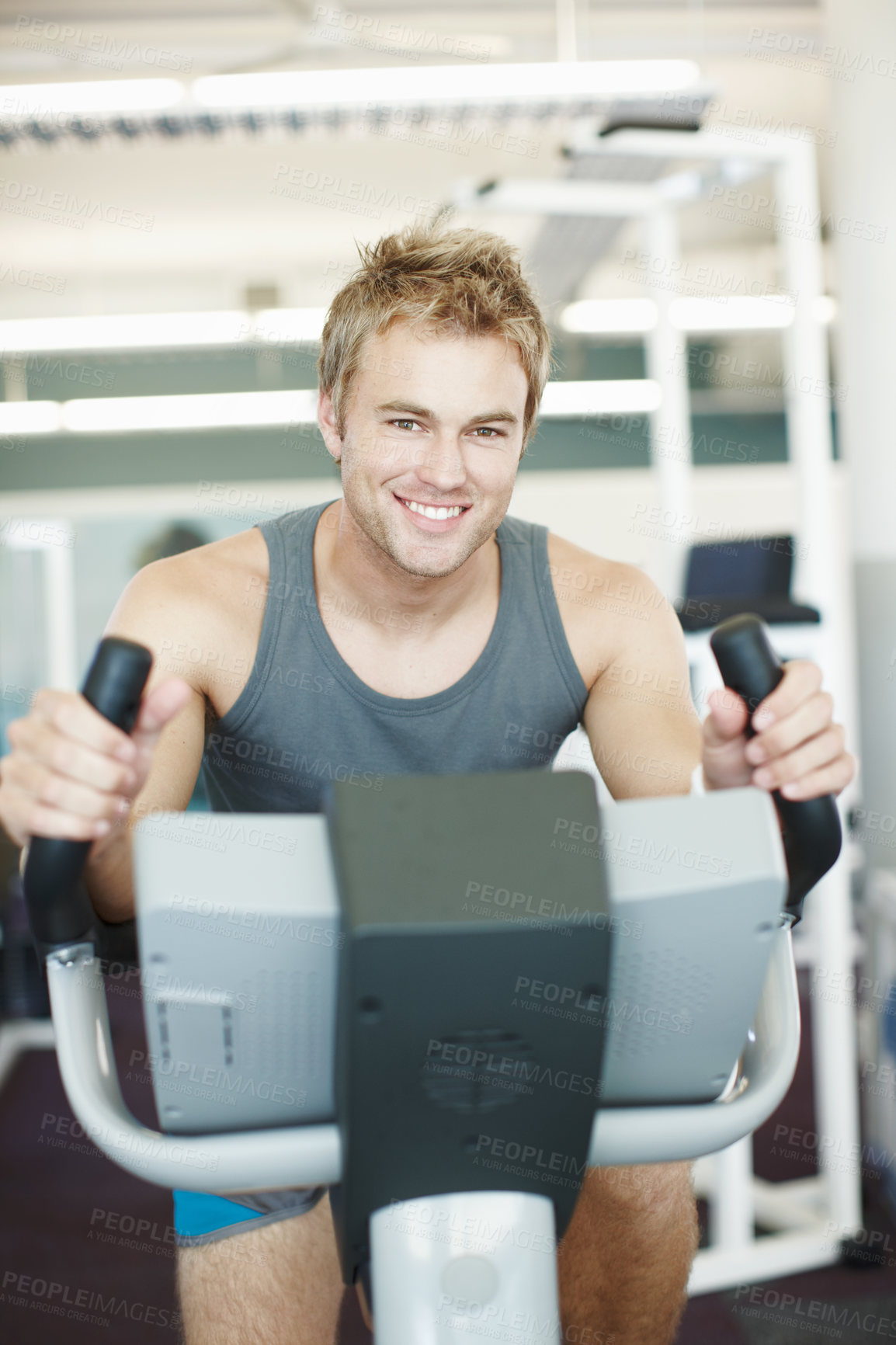 Buy stock photo Happy man, portrait and fitness with bike exercise at gym for cardio workout or indoor training on equipment. Young, male person or active athlete with smile for cycling and wellness at health club