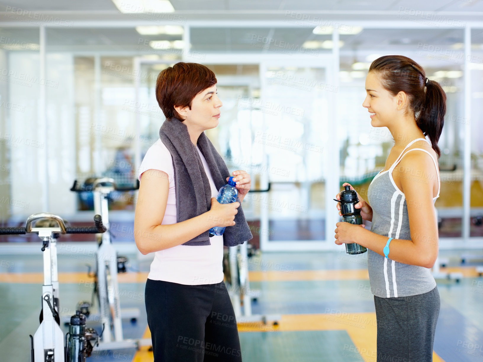 Buy stock photo Two girls talking and looking at each other in the gym