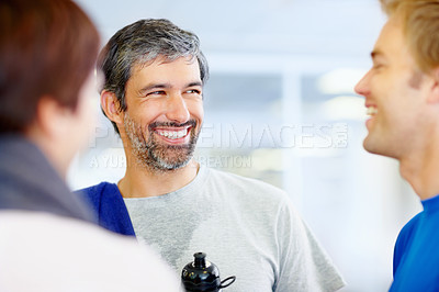 Buy stock photo Portrait of smiling mature man talking with friends at fitness center