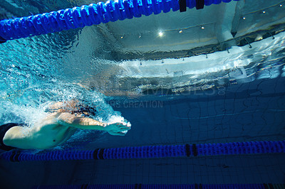 Buy stock photo A young male competitor swimming freestyle in a pool