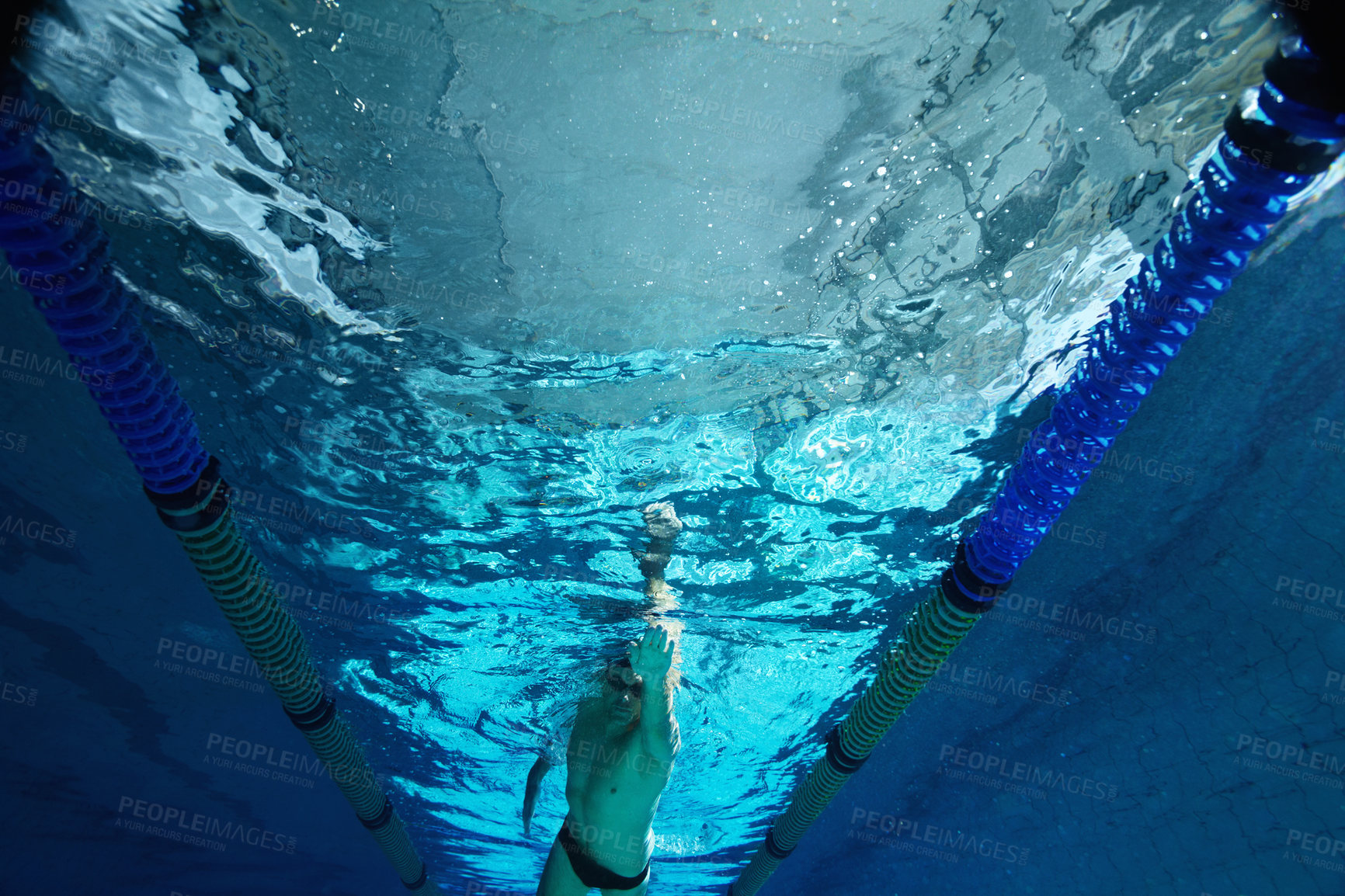 Buy stock photo Fitness, underwater and swimming with man in pool for workout, wellness and training for competition. Athlete, swimmer and arm with liquid in low angle for exercise, freestyle and sports challenge