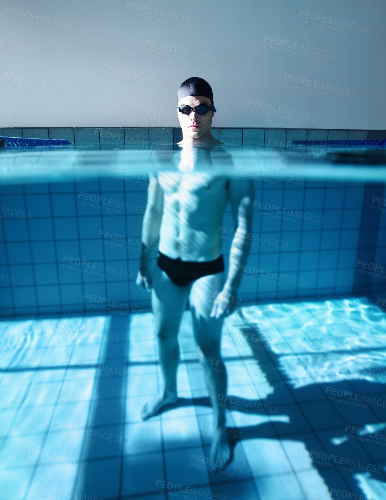 Buy stock photo Portrait of a young male swimmer standing in a swimming pool