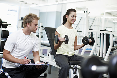 Buy stock photo Personal trainer, woman and dumbbell with writing, clipboard and assessment for progress at gym. People, man and coach with checklist for stats, fitness and exercise with notes at wellness club