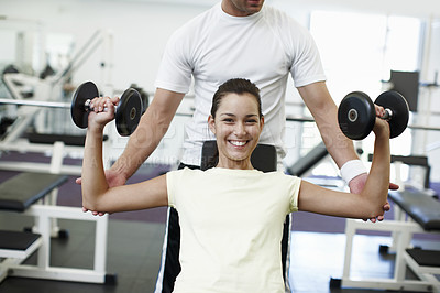 Buy stock photo Cropped portrait of an attractive young woman weight training with her personal trainer