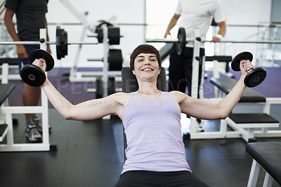 Buy stock photo Cropped portrait of an attractive young woman weight training at the gym