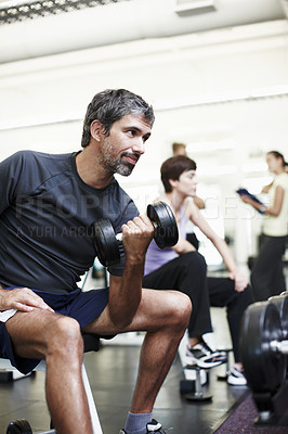Buy stock photo Cropped shot of a handsome man working out with weights in the gym