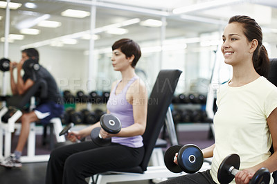 Buy stock photo Cropped shot of people working out with dumbbells in the gym