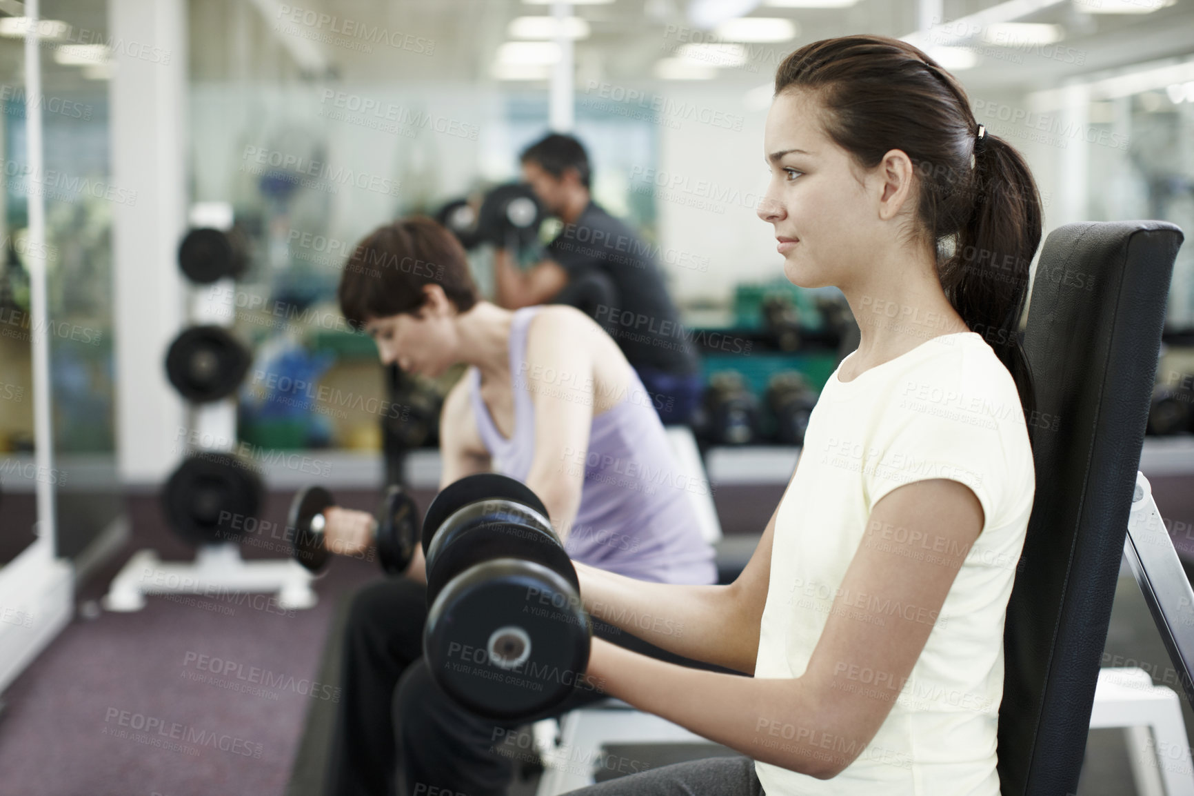 Buy stock photo Cropped shot of people working out with dumbbells in the gym