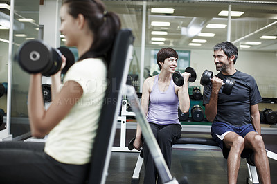 Buy stock photo Cropped shot of people working out using dumbbells in the gym 