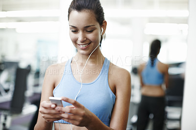 Buy stock photo Cropped shot of an attractive young woman listing to music in the gym