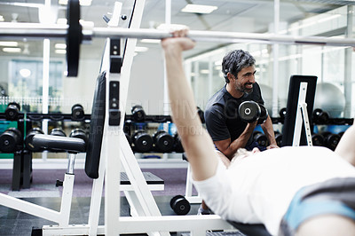 Buy stock photo Cropped shot of two men lifting weights in the gym