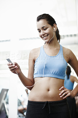 Buy stock photo Cropped shot of an attractive young woman listing to music in the gym