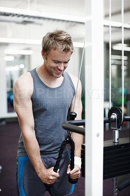 Buy stock photo Cropped shot of a handsome young man exercising in the gym