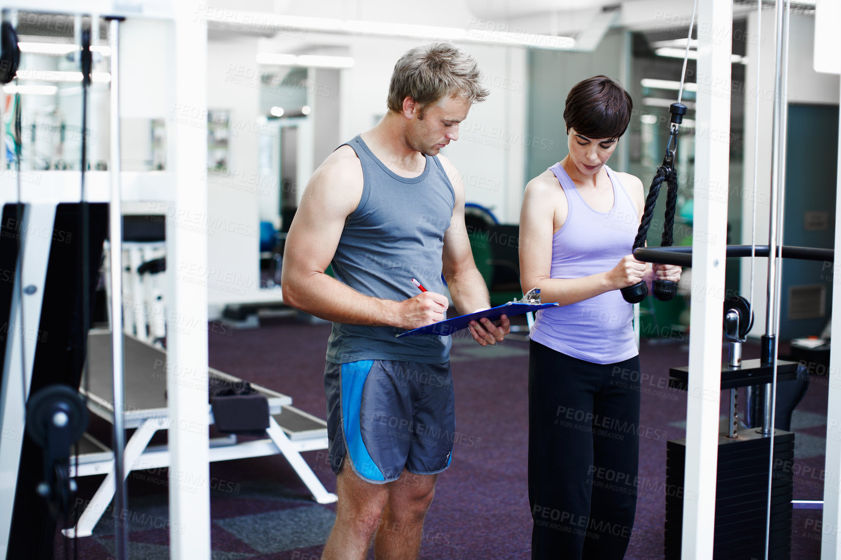 Buy stock photo Coach, woman and clipboard with weightlifting machine, assessment and progress at gym. People, man and personal trainer with checklist with workout, fitness and exercise with notes at wellness club