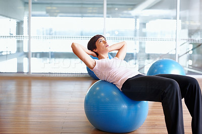 Buy stock photo Woman doing sit ups using pilates ball in a gymnasium