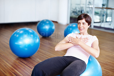 Buy stock photo Healthy woman doing abdominal sit ups on exercise ball