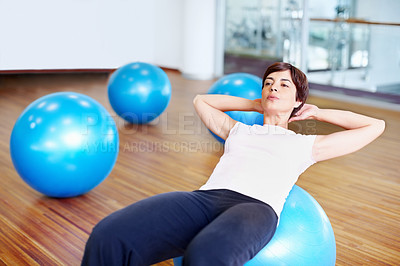 Buy stock photo Woman doing sit ups using fitness ball in a gymnasium