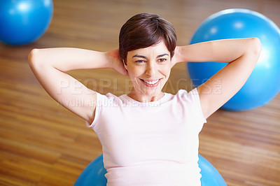 Buy stock photo Smiling woman using sports ball and doing sit ups during her workout