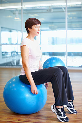 Buy stock photo Full length of woman sitting on exercise ball and planning her next workout routine