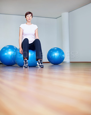 Buy stock photo Full length of woman sitting on pilates ball with eyes closed