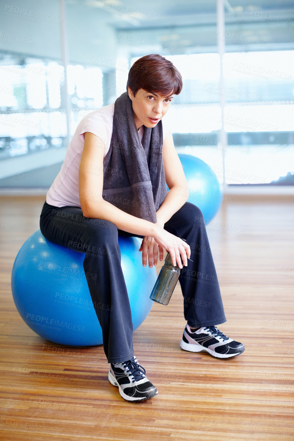 Buy stock photo Portrait, woman and exercise ball with towel in fitness studio for wellness, gym or training. Female person, tired and relax for workout, sport or health as athlete in pilates, rest or cardio routine