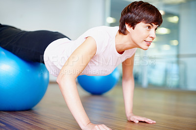 Buy stock photo Woman doing push ups using pilates ball during a workout session
