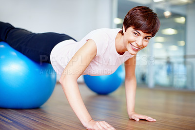 Buy stock photo Portrait of woman doing push ups on pilates ball and smiling