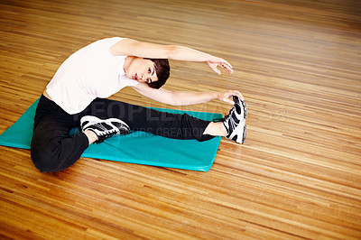 Buy stock photo Full length of an attractive woman doing stretching on a mat