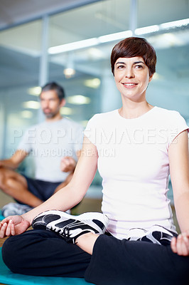 Buy stock photo Full length of a beautiful woman in lotus position with man in background