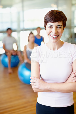 Buy stock photo Portrait of fitness trainer with people practicing yoga in background